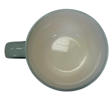 Load image into Gallery viewer, A green ceramic mug showing its cream colored inside
